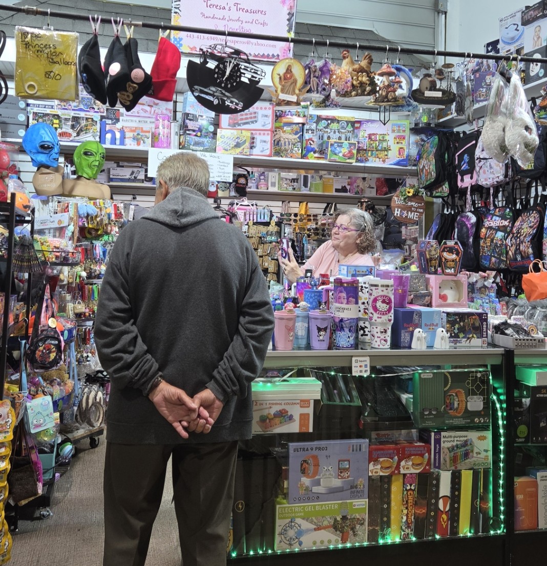 A vendor arranging merchandise at an indoor market table